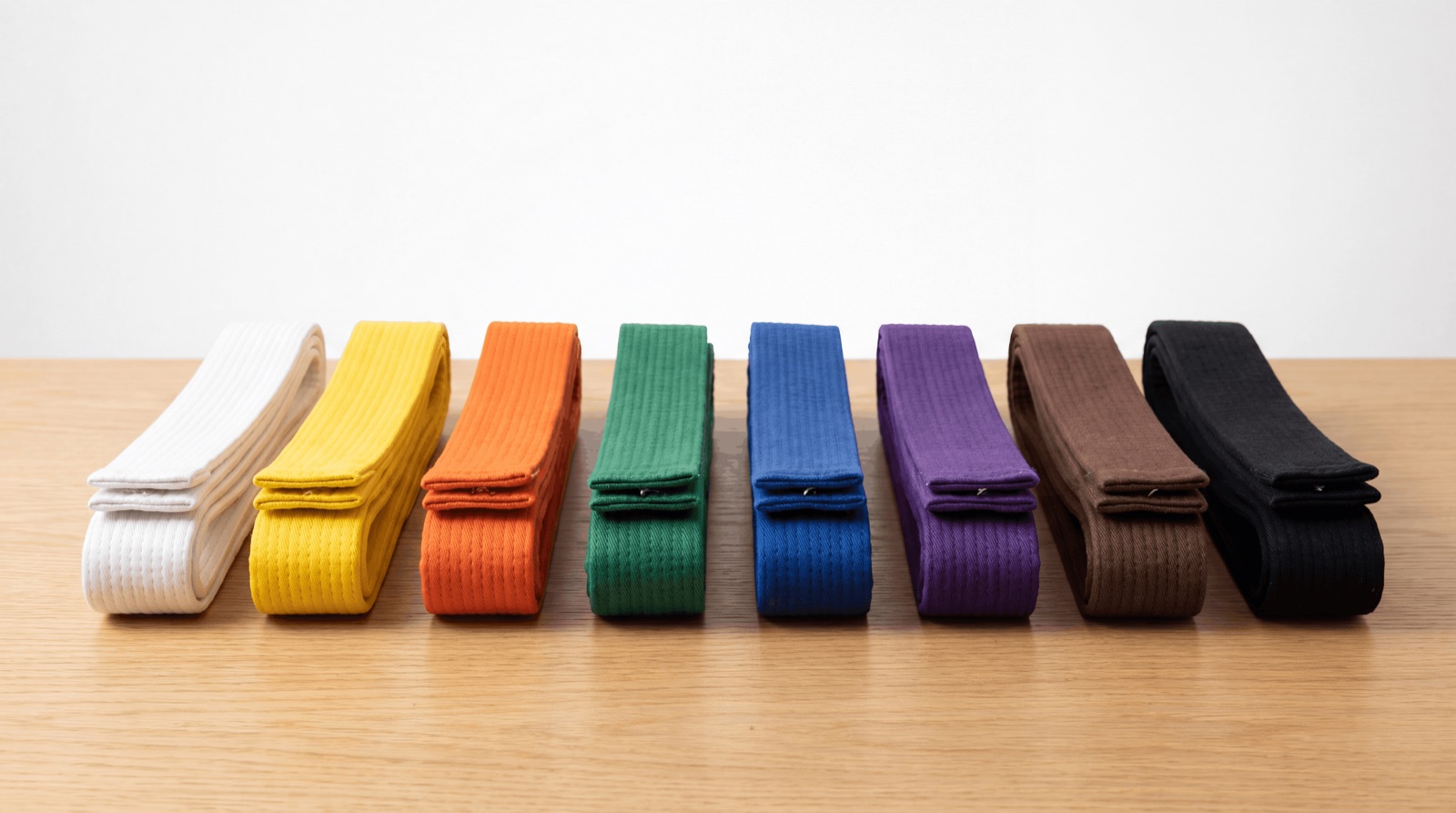 karate belts in order from white to black belt showing the full colour progression